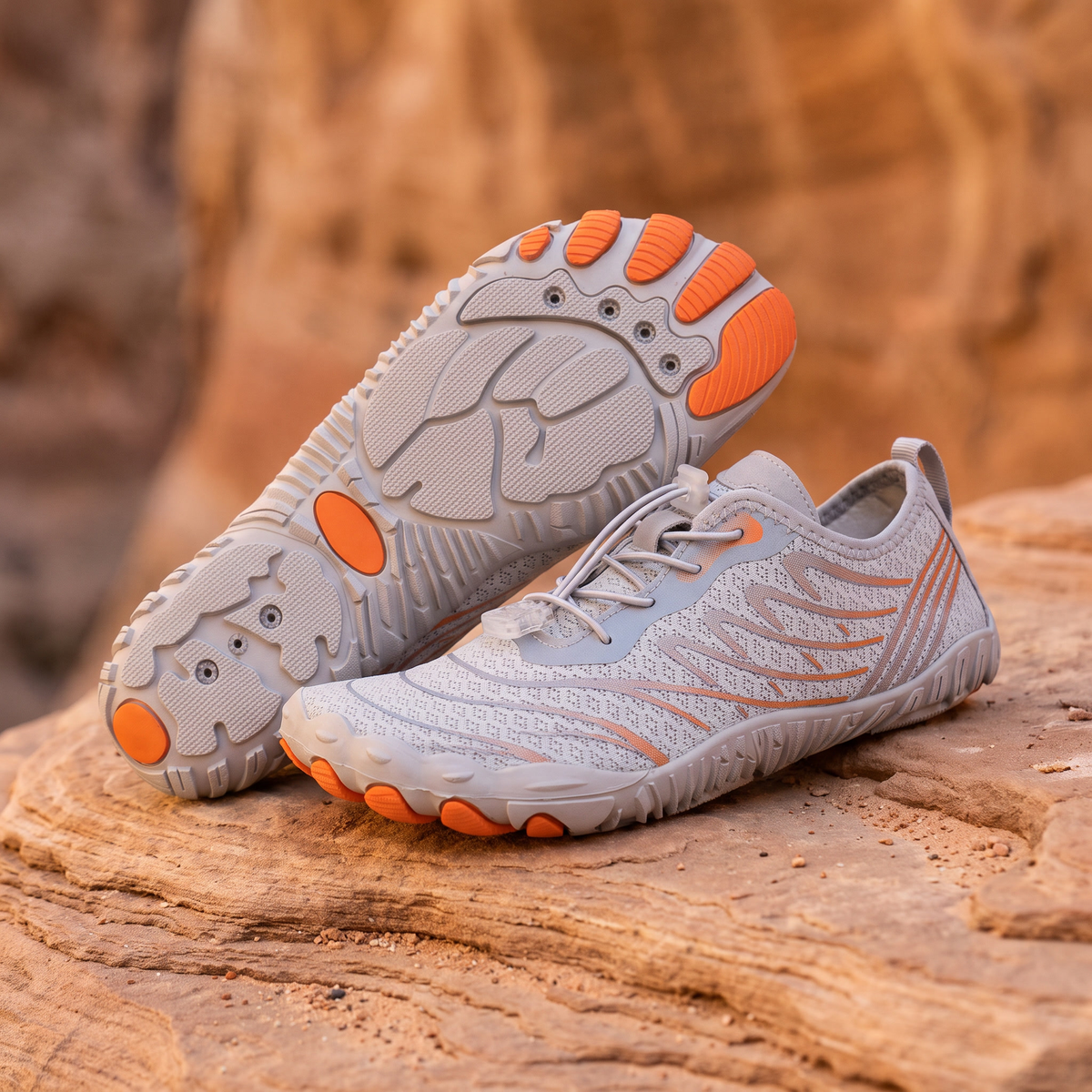 Grey Orange water trekking shoes on warm sandstone rock